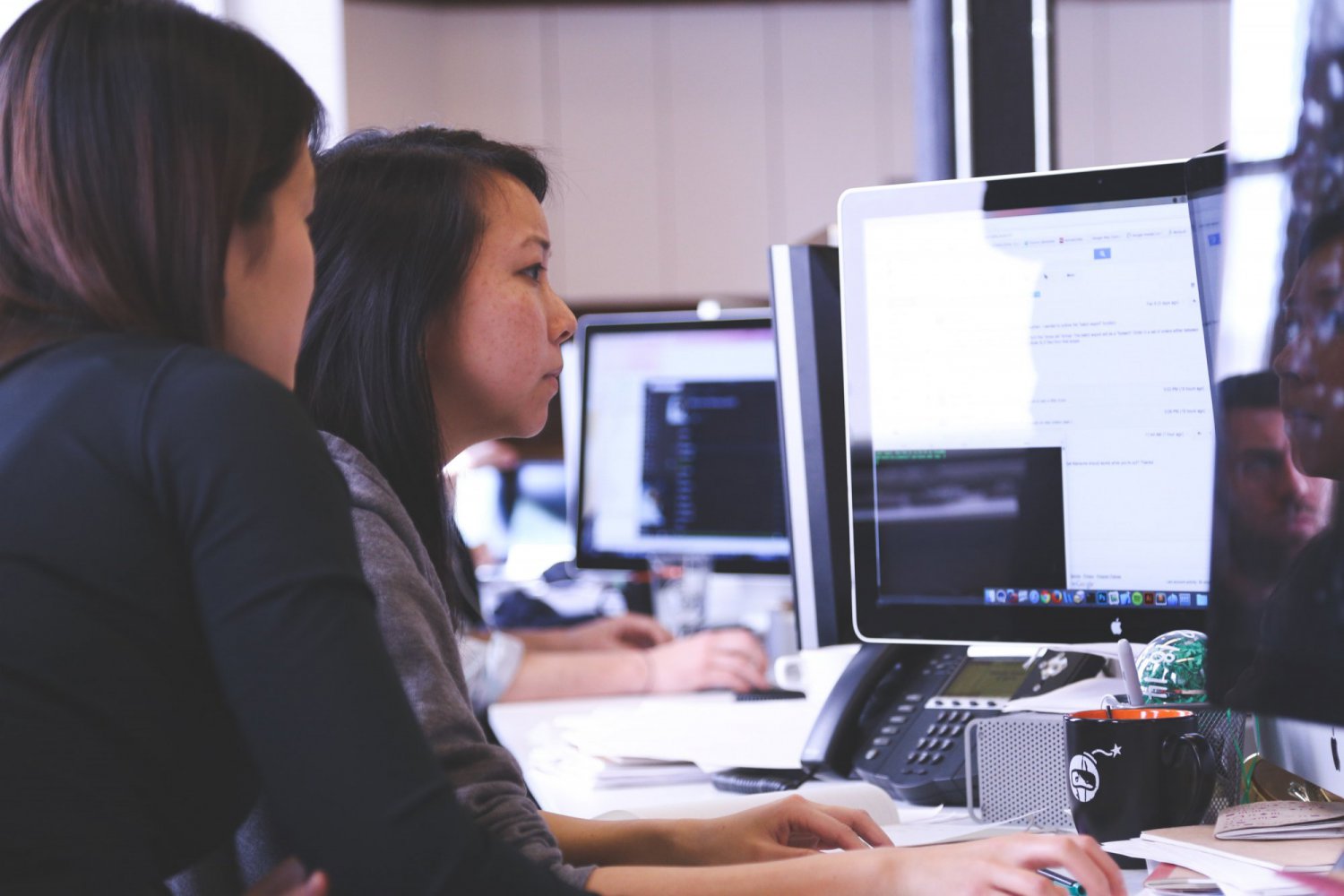 two women sat at a computer screen